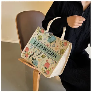 Close-up of floral print canvas tote bag with woven texture and FLOWERS lettering detail
