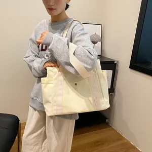 Large beige canvas tote bag with pink straps shown by a model for daily commute
