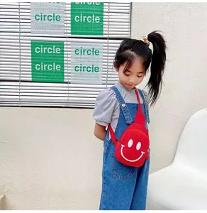 Gros plan sur un sac de poitrine rouge pour enfants avec motif smiley blanc stylé