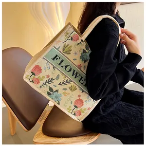Macro view of vintage linen tote bag with colorful floral embroidery and FLOWER text