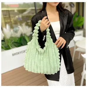 Detail of light green faux fur tote bag with textured stripes and wavy handle edges