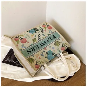 Close-up of floral jacquard embroidery tote bag with FLOWERS text and magnetic closure