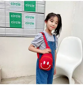 Gros plan du sac bandoulière rouge pour enfant avec motif smiley et sangle