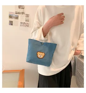 Detailed view of the blue corduroy mini tote bag with a cute bear embroidery patch