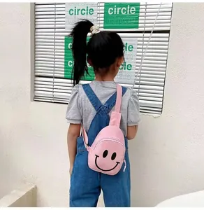 Vue arrière d'un enfant portant le sac de poitrine en toile rose avec imprimé smiley