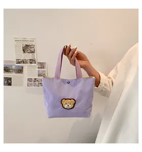 Detail of lavender corduroy tote bag with bear embroidery and metal snap button