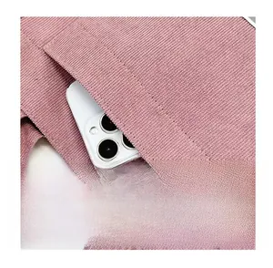 Detailed view of pink corduroy tote bag front pocket with a smartphone inside