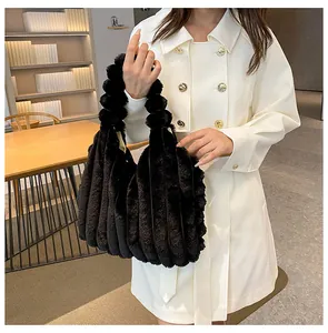 Detail shot of black plush tote bag featuring vertical pleated faux fur texture on handle