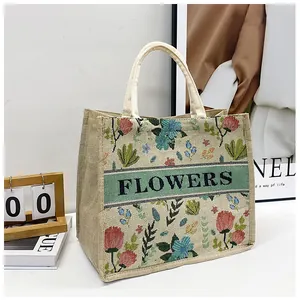 Detail of floral embroidery and FLOWERS text on a minimalist linen tote bag