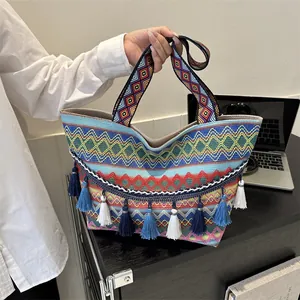 Ethnic bohemian woven tote bag with colorful geometric patterns and blue fringe tassels
