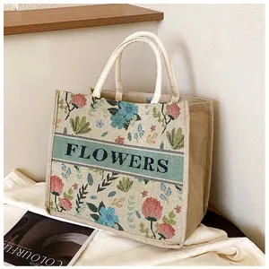 Detailed close-up of ethnic linen tote bag with colorful flower embroidery and Flowers text