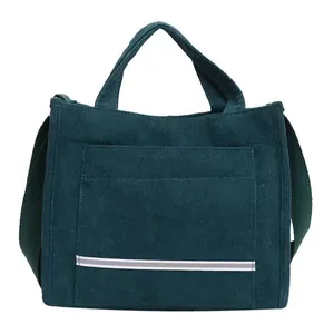 Dark green corduroy tote bag with reflective strip and shoulder strap on white background