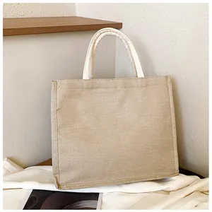 Detail view of woven jute fabric texture and cotton handles on a large tote bag