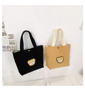 Detail of mini corduroy tote bags with cute bear embroidery and metallic snap closure