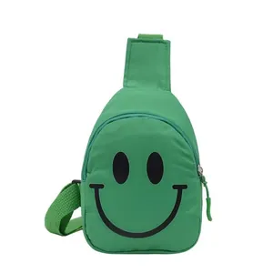 Sac de poitrine vert pour enfants avec motif smiley et bandoulière réglable sur blanc