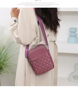 Détail d'un sac bandoulière violet en nylon avec broderie étoile et poches zippées multiples
