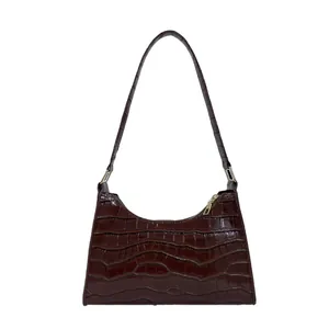 Donkerbruine baguette tas van imitatiekrokodillenleer met minimalistische retro schouderriem