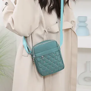 Sac bandoulière matelassé vert sarcelle avec broderie florale et double fermeture