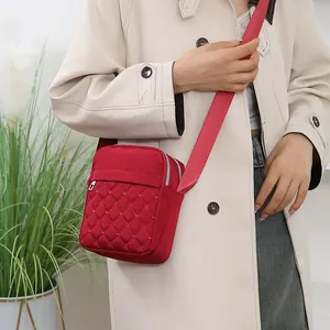 Sac bandoulière en nylon rouge matelassé pour femme avec plusieurs compartiments zippés