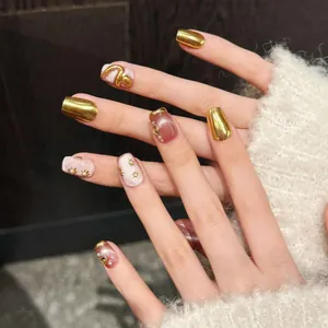 Détail de faux ongles faits main avec serpent doré, perles et effet œil-de-chat