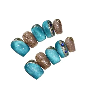 Neon cat-eye handmade press-on nails with 3D metal trim and blue rhinestones