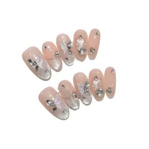 Faux ongles faits main avec effet œil de chat blush glacé et breloques papillon 3D