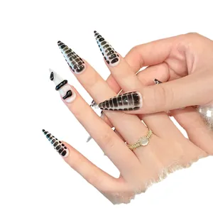 Long stiletto press-on nails with black and white python texture and 3D embossed accents