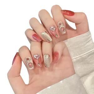 Pink cat eye press-on nails with luxury crystal rhinestones and golden accents