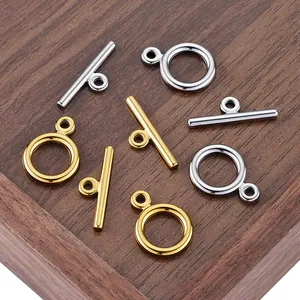 Polished gold and silver OT toggle clasps for DIY jewelry making on a dark wooden box