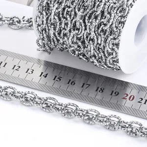 Detailed macro view of diamond-cut stainless steel oval chain measured by a metal ruler