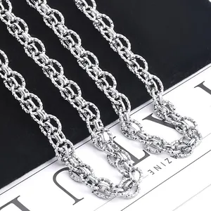 Close-up of silver stainless steel chain with double-woven oval links and textured patterns