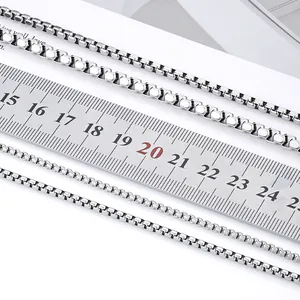 Detailed comparison of four different sizes of silver box chains with measuring ruler