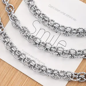 Diamond-cut silver stainless steel double link oval chain shown on a wooden background