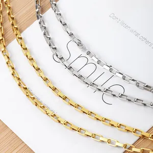 Polished gold and silver stainless steel box chain necklaces shown on a wooden background