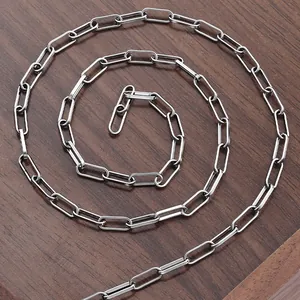 Polished stainless steel paperclip chain necklace on dark wood background