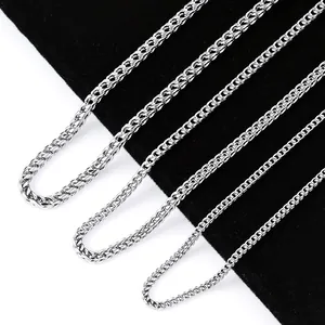 Detailed close-up of various thicknesses of polished silver stainless steel wheat chains