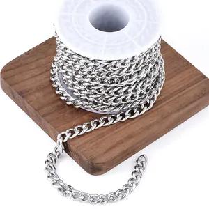 Macro detail of silver stainless steel Cuban link chain roll on a wooden board