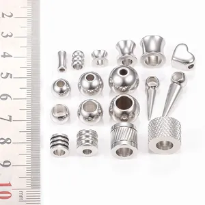 Verschiedene Edelstahl-Zwischenperlen für DIY-Schmuck, präsentiert mit einem metrischen Lineal