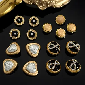 Golden metal earring collection featuring camellia pearls and vintage rhinestones