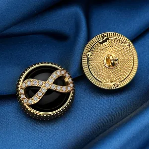 Macro view of gold infinity symbol buttons with crystals on dark blue satin fabric