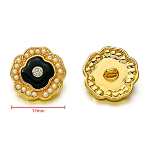 Detail of 17mm gold metal flower button with black enamel, pearls, and zircon inlay