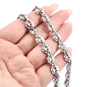 Mechanische Zahnrad-Schweinenasen-Edelstahlkette in der Hand vor weißem Hintergrund