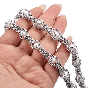 Handmade stainless steel cage chain with white pearls showing the intricate weave design