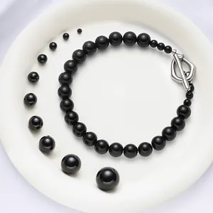 Polished black ABS faux pearl necklace with silver T-clasp and multi-size bead display