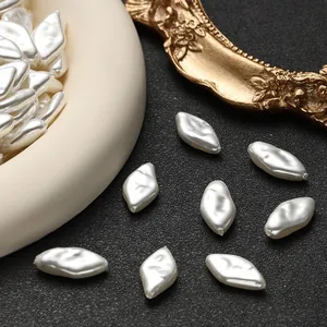 Makroaufnahme cremeweißer unregelmäßiger Perlen für DIY-Schmuck mit Lochdetails