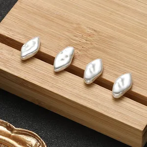 Detailansicht vier unregelmäßiger Barockperlen auf Holzständer für DIY Schmuckdesign