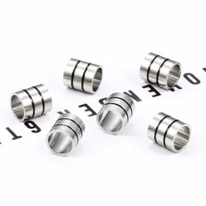 Detailed macro view of six cylindrical stainless steel beads with black enamel stripes