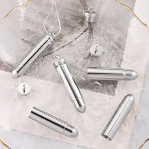 Polished stainless steel bullet pendant necklace with screw top closure on marble tray