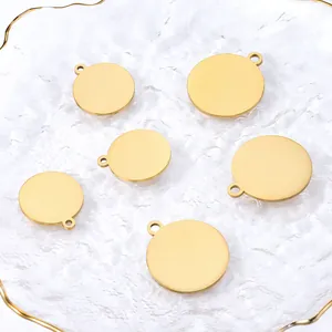 Detailed view of six polished gold stainless steel round charms for DIY jewelry making