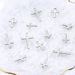 Detalle de colgantes de cruz en acero inoxidable plateado para creación de joyas de bricolaje